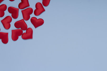 Red hearts on blue background top view. Valentine day greeting card. Copy space