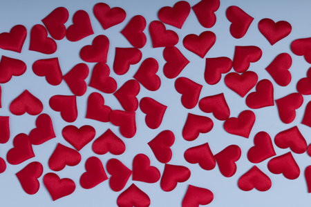 Red hearts on blue background top view. Valentine day greeting card.の写真素材