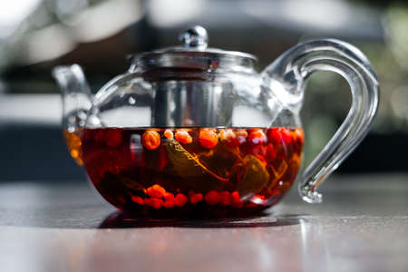 Glass teapot with hot red berry tea, close-up view.の写真素材
