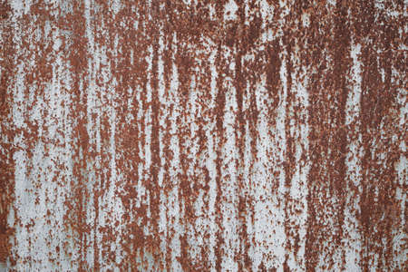old sheet of iron covered with rust with white colored paint. rusty metal surface textureの写真素材