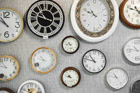 Wall clocks hanging on the wall for sale at watch Store. Various types and brands of wall clocks.