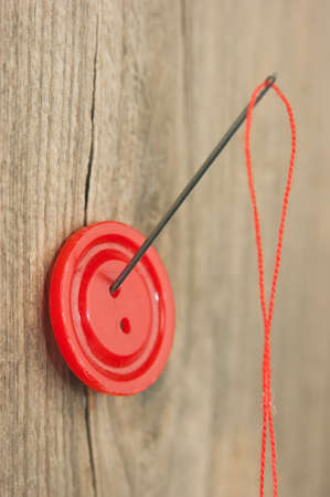 Buttons with needle and thread on the board