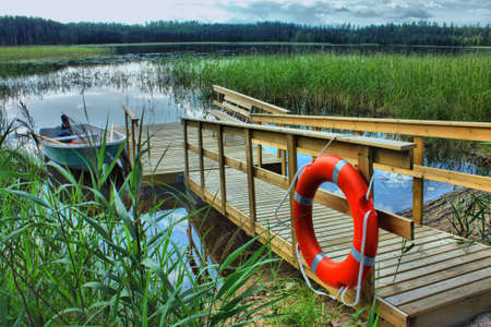 boat with a wooden pier with a lifeline in the reeds on the lakeの写真素材