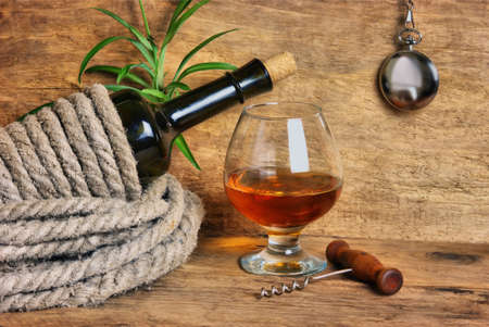 bottle of wine wrapped with rope on the background of the old wooden planksの写真素材
