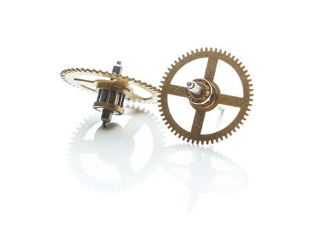 gears from old clock isolated on white background with reflectionの写真素材