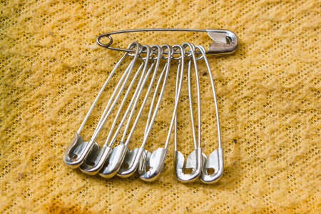 Safety pin pinned to the texture color fabricの写真素材