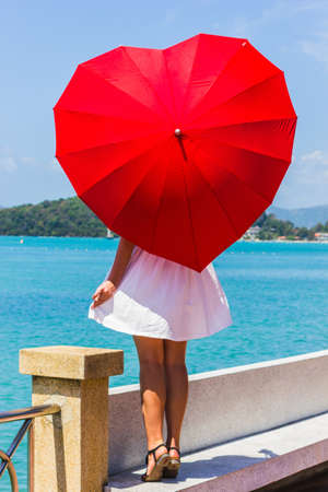 Girl with an umbrella against the sea in Thailandの写真素材