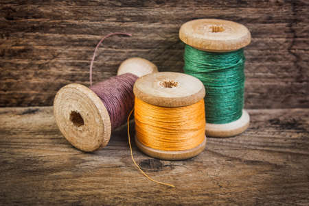 Spools of thread on a background of the old wooden planksの写真素材