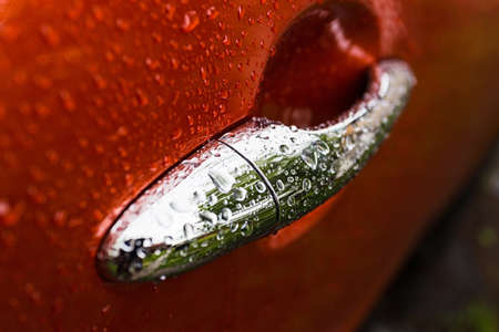 Handle orange car is wet from the rainの写真素材