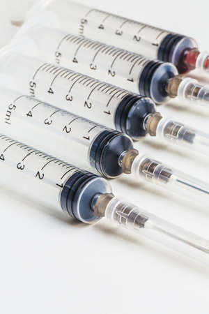 Closeup, Disposable syringe in the row on white の写真素材