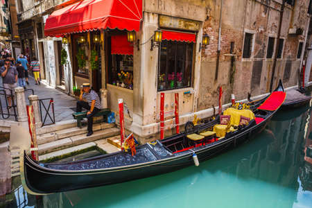 VENICE, ITALY - JUNE 26: Tourists travel on gondolas at canal on June 26, 2014 in Venice, Italy . Gondola trip is the most popular touristic activity in Venice.のeditorial素材