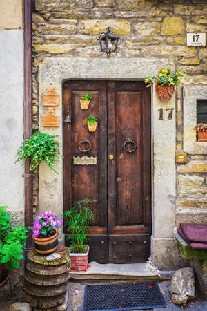 ITALY - JUNE 23, 2014: Windows and doors in an old house decorated with flower pots and flowersのeditorial素材