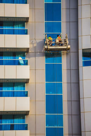 window cleaners in a gondola cleaning the windows of a corporate office skyscraper.の写真素材