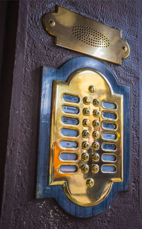 Old italian wooden door with a metal intercom