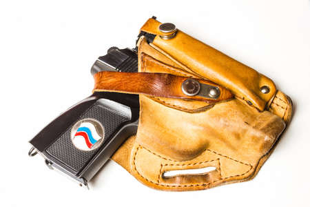 Black gun in a brown leather holsterの写真素材