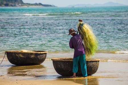 NHA TRANG, VIETNAM - NOV 28: Unidentified fishermen is working on the beach in Nha Trang, Vietnam. On Nov 28, 2014.のeditorial素材
