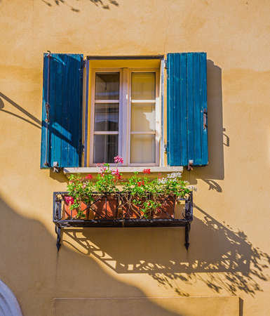 Window in an old house decorated with flower pots and flowersの写真素材