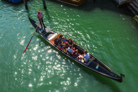 VENICE, ITALY - JUNE 26: Tourists travel on gondolas at canal on June 26, 2014 in Venice, Italy . Gondola trip is the most popular touristic activity in Venice.のeditorial素材