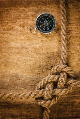 Compass with a rope on the background of the old boardの写真素材