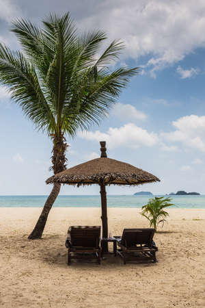 beach umbrellas and deck chairs on the shores of paradiseの写真素材