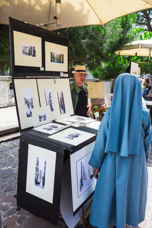 VENICE, ITALY - 26 JUNE, 2014: Artist sells paintings on the waterfront in Venice, Italyのeditorial素材