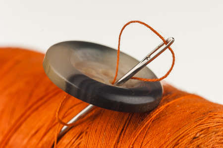 Button pinned the needle to the reel of thread