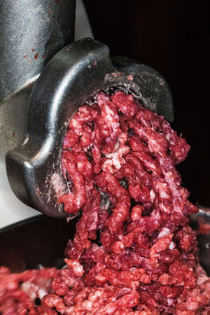fresh minced meat in mincing machine in the kitchenの写真素材
