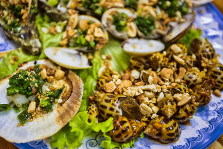 Fresh oysters in a  plate with spice and lemon on a wooden deskの写真素材
