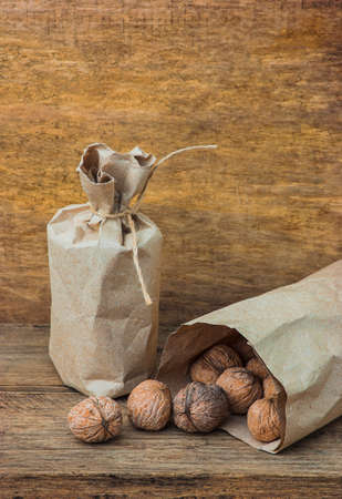 Walnuts in paper bags on the background of an old wooden boardの写真素材