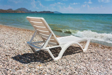 white chaise lounge on the beach in sunny day