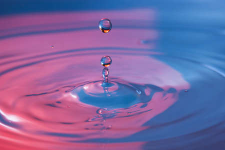 Water drop falling into water making a perfect concentric circles
