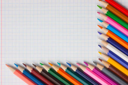 Pencils of different colors  at the cellular backgroundの写真素材