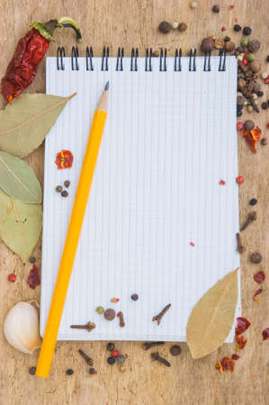 notebook to write recipes on the background of a cutting board with spicesの写真素材