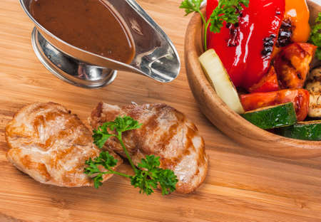 Grilled pork with spicy salad and baked vegetablesの写真素材