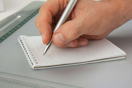 Write with a ballpoint pen in a notebook
