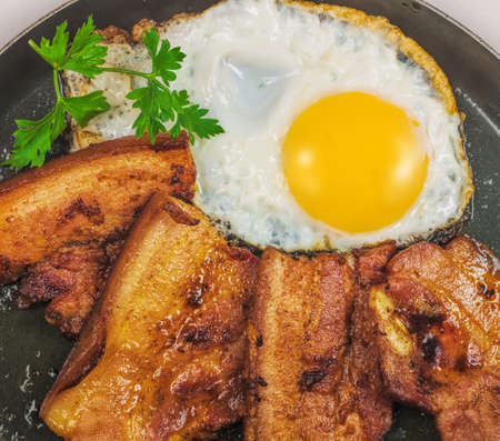 fried egg with bacon and greensの写真素材