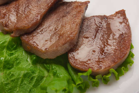 Boiled beef tongue with vegetables is served on a plate in a restaurantの写真素材
