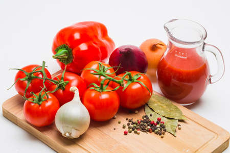  tomatoes and tomato juice on a wooden tableの写真素材