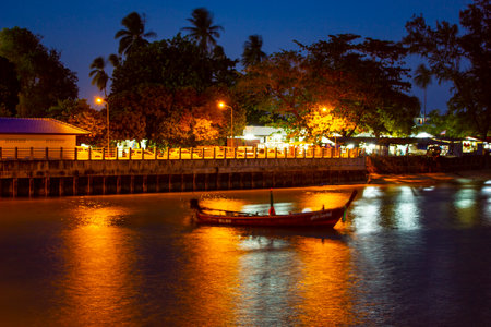 Pier at night with yellow lights on a background of blue sky stretching into the seaの写真素材