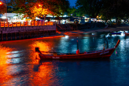 Pier at night with yellow lights on a background of blue sky stretching into the seaの写真素材