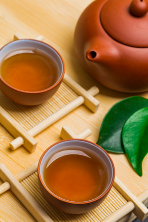 Teapot and a cup of green tea on wooden tableの写真素材