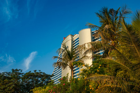 DUBAI, UAE - November 15: Palm trees waving in the wind and giant chess board in front of Jumeirah Beach Hotel, wave-shaped luxury resort, well-known Dubai landmark, on November 15, 2012, Dubai, UAE.のeditorial素材