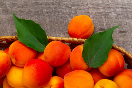 Apricots with leaves on the old wooden tableの写真素材