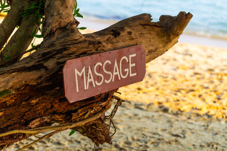 Old signboard with the inscription, massage, on a tropical beach. Thailand