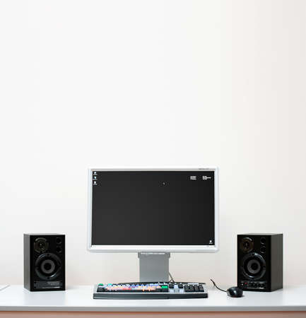 Computer system setup with speakers, monitor for video editing on a white deskの写真素材