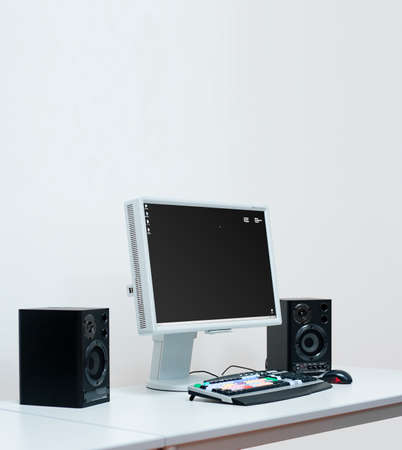 Computer system setup with speakers, monitor for video editing on a white deskの写真素材