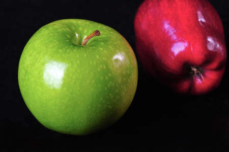 A green and a red apple on a black background  の写真素材