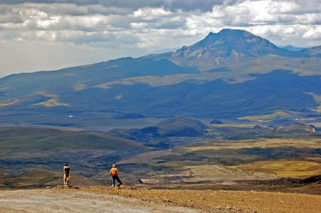 Two men enjoying the view of a valley and the Sincholagua volcanoの写真素材