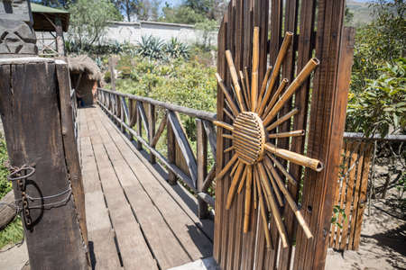 Wooden door with a sun decoration made of sugar canesの写真素材