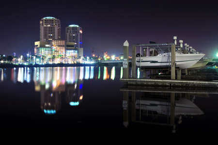 Boats at a pier at nightime with iluminated buildings in the backgroundのeditorial素材